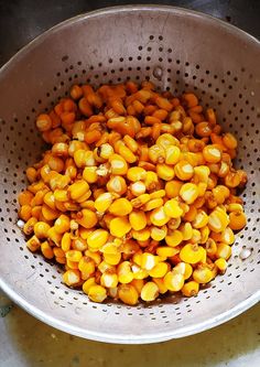 a metal colander filled with corn on the cob