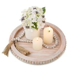 a wooden tray with candles and flowers on it