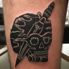 a man's leg with a tattoo on it and a skull holding a knife