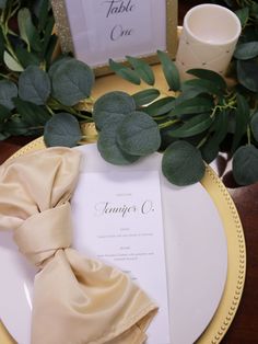 a place setting with napkins and greenery