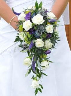 a bridal holding a bouquet of white and purple flowers