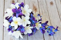 a bouquet of purple and white flowers sitting on top of a wooden floor