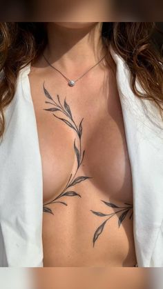 a woman's chest with tattoos on it, and the top part of her shirt showing