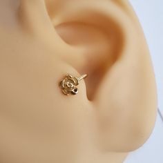 a close up view of a gold earring on a mannequin head