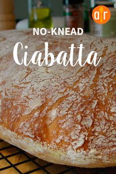 a loaf of ciabatta sitting on top of a cooling rack with the words no - knead ciabatta above it