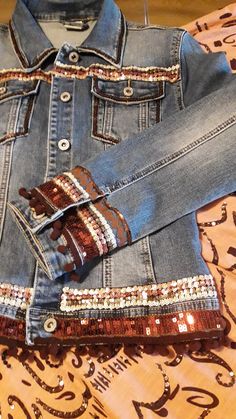 an old pair of jeans is laying on a table with beads and sequins