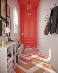 the hallway is painted bright red and has multicolored stripes on the flooring