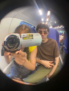 a man and woman taking a selfie on a train