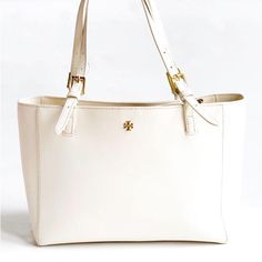 Description Tory Burch Tote White Leather Gold-Tone Hardware Flat Handles & Dual Shoulder Straps Logo Jacquard Lining & Five Interior Pockets Open Top Open To Offers Estimated Item Measurements Shoulder Strap Drop: 8.75" Height: 10.75" Width: 17" Depth: 5.5" Color: White Shoulder Strap Length: 8.75" Tory Burch Emerson, Tory Burch Tote, Tory Burch Bags, Tory Burch Bag, Open Top, Cream White, Womens Tote Bags, White Leather, Leather Tote