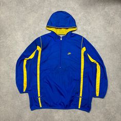 Early 2000's Vintage Nike Blue and Yellow Quarter-Zip Hooded Track Jacket with central swoosh on back  size - XL width - 29" length - 30" Blue And, Nike Vintage, Nike Blue, Blue And Yellow, Track Jacket, Men's Coats And Jackets, Track Jackets, Vintage Nike, Mens Coats