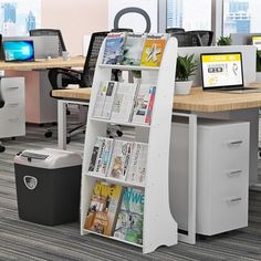 an office cubicle with several computers and magazines