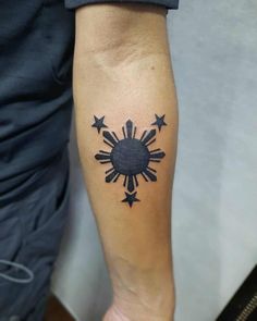 a person with a tattoo on their arm that has stars in the shape of a sun