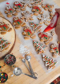 a person is decorating christmas cookies on a table