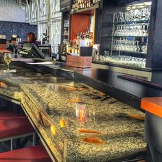 an empty bar with goldfish in the foreground and red chairs at the back