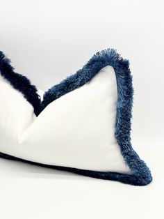 a blue and white pillow on a white surface