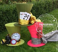 three hats are stacked on top of each other in the grass, one has a clock