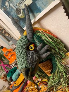 a close up of a stuffed animal head on a wall with other items in the background