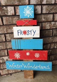 a christmas tree made out of wooden planks with the words frosty and winter wonderland painted on it