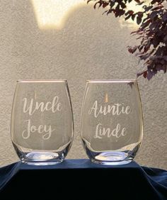 two wine glasses sitting on top of a table next to each other with the words uncle joe and annie june written on them