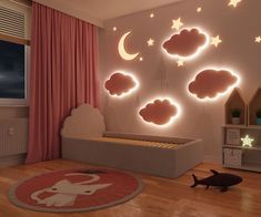 a child's room decorated in pink and white with stars, clouds, and a cat on the floor