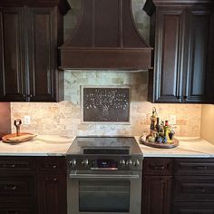 a stove top oven sitting inside of a kitchen next to wooden cabinets and counter tops