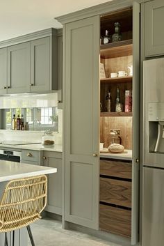 a kitchen with gray cabinets and white counter tops