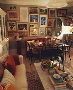 a living room filled with furniture and lots of pictures on the wall above it's coffee table