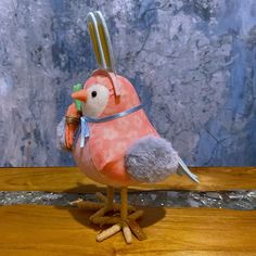 a small stuffed bird is on a wooden table