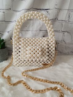 Elegance meets opulence in this beaded pearl bag. Elevate your style with a touch of sophistication and luxury. Dimension: Width: 16cm Height: 12cm Depth: 8cm The bag comes with a detachable handle which measures 110cm. Feel free to contact me for any questions. Glamorous Pearl Clutch With Pearl Handle, Chic Rectangular Pearl Clutch, Elegant Party Bag With Pearl Chain, Chic Beige Pearl Evening Bag, Elegant Party Bags With Pearl Chain, Rectangular Pearl Evening Bag With Pearl Embroidery, Luxury Pearl Clutch With Pearl Handle, Luxury Evening Bag With Pearl Embroidery, White Evening Bag With Pearl Chain