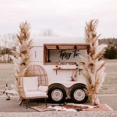 a food truck parked in the middle of a field with tall grass growing out of it