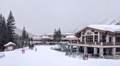 people are skiing in front of a ski lodge