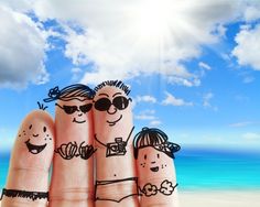 two fingers with drawings of people on them next to sunscreen and body lotion