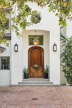 an entrance to a house with a wooden door and brick walkway leading up to it