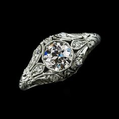 an antique style diamond ring with filigrees and blue stones in the center