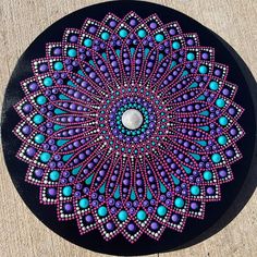 a black plate with purple and blue designs on it