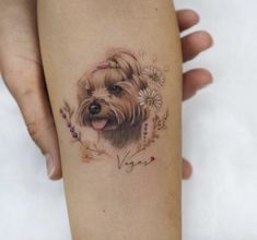 a woman's leg with a small dog tattoo on it