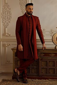 Maroon long sleeves sherwani in silk base with all over resham sequin embroidery and band collar neckline. Paired with matching dupatta and plain churidar.
Components: 3
Pattern: Embroidery
Type Of Work: Resham Sequin
Neckline: Band Collar
Sleeve Type: Long
Fabric: Silk
Color: Maroon
Occasion: Wedding, Sangeet - Aza Fashions Indian Sherwani Wedding, Sangeet Groom Outfit, Maroon Sherwani Groom, Mens Wedding Wear Indian, Sangeet Outfit For Men, Maroon Sherwani, Dusk Wedding, Groom Indian Wedding Outfits, Dark Red Suit