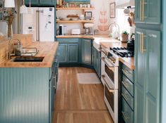 a kitchen with blue cabinets and wooden floors