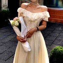 a woman in a white dress is holding flowers