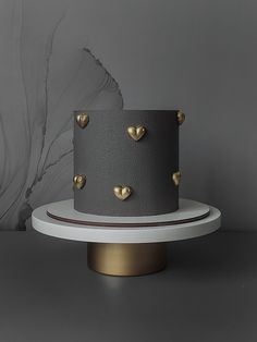 a grey and gold cake with hearts on it