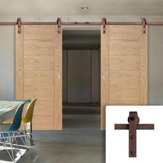 a cross is in the middle of a room with wooden doors and chairs around it