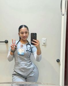 a woman with a stethoscope on taking a selfie in front of a mirror