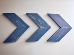 three blue arrows are hanging on the wall