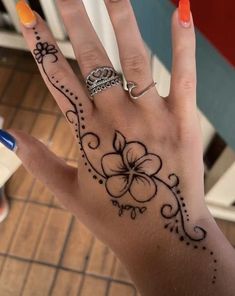 a woman's hand with a flower and crown tattoo on her left palm, which is decorated with black dots