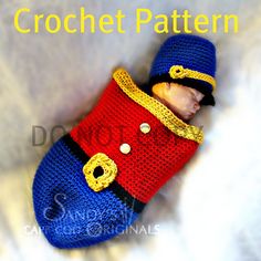 a crocheted doll is wearing a red and blue outfit with yellow buttons on it