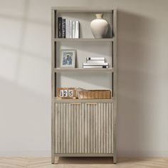 a book shelf with books and pictures on it in an empty room next to a vase