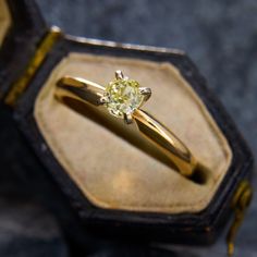 a close up of a ring in a box with a diamond on the top and bottom