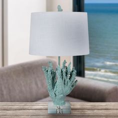 a blue coral lamp sitting on top of a wooden table