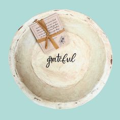 a wooden bowl that has some type of paper in it with the word grateful written on it