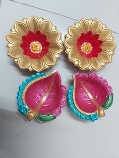 three decorative flower shaped dishes sitting on top of a table